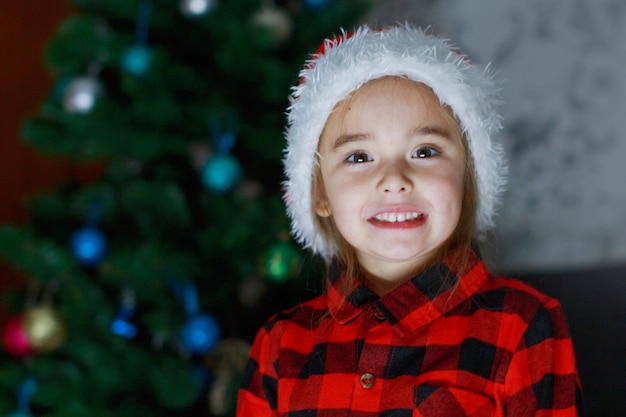 A child in red clothes is sitting waiting for the new year. the concept of celebrating Christmas at midnight. holiday costume