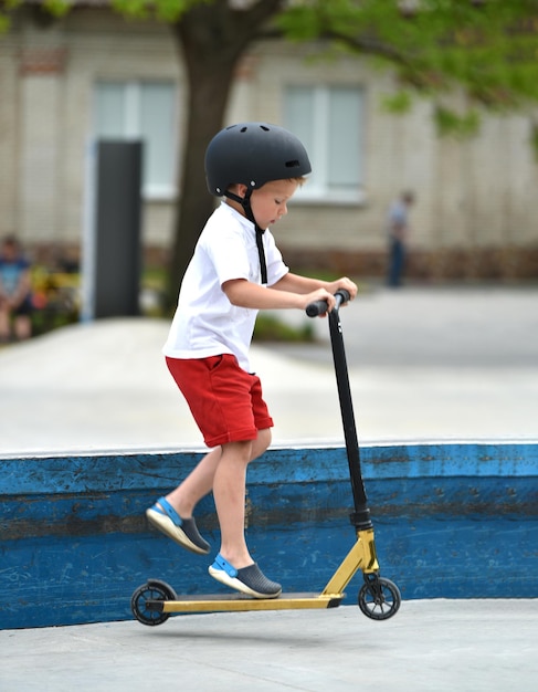 Photo a child rides a kick scooter playground for riding on kick scooter