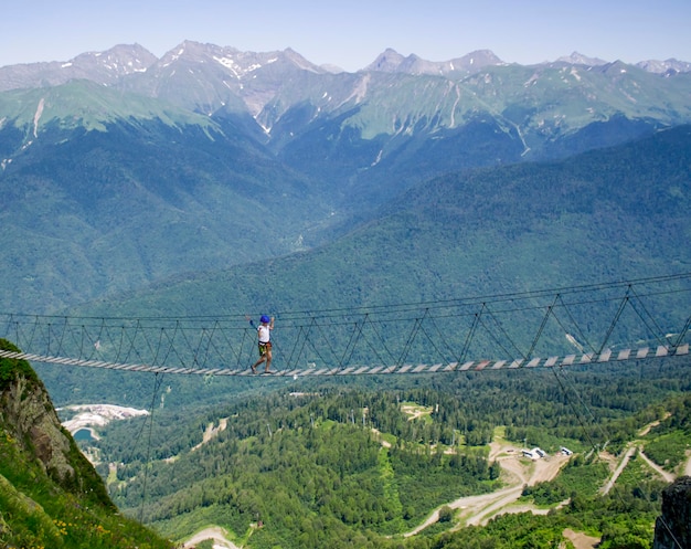 A child on a rope bridge in the mountains