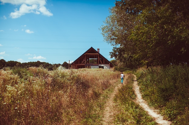 Child runs along the path to the house 