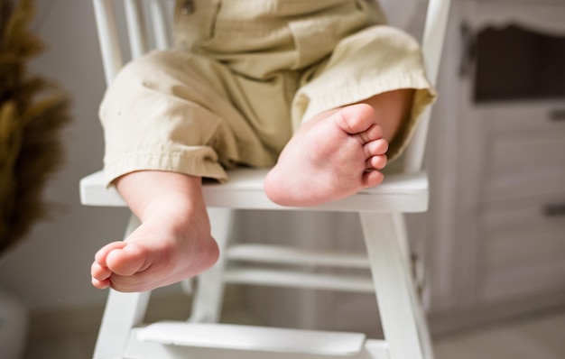 A child's feet in closeup on a high chair