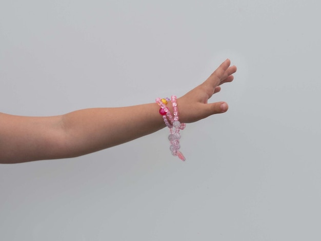 A child's hand with a bracelet of colorful beads a place for text