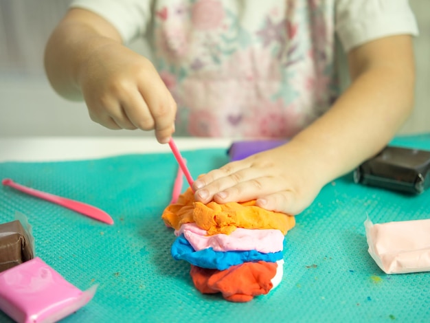 The child's hands play with plasticine closeup the development of motor skills and hand sensory