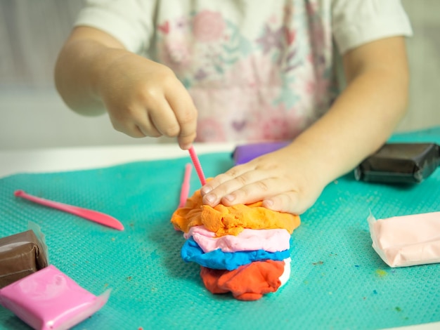 The child's hands play with plasticine closeup the development of motor skills and hand sensory