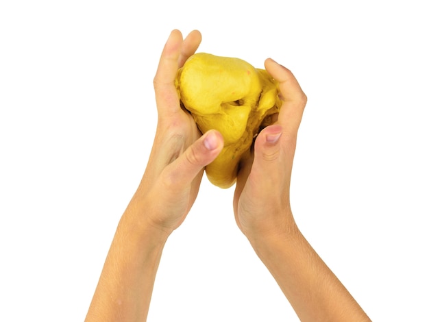 The child's hands squeeze a lump of yellow lime isolated. Toy antistress. Toy for the development of hand motor skills.