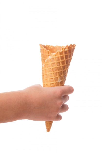 Child's little hand holding empty waffle cornet isolated