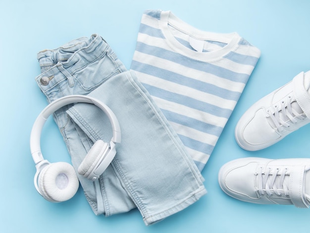 Child's tshirt shoes and headphones on blue backgrund