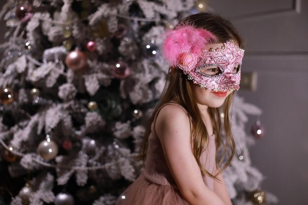 Child in smart clothes in front of the Christmas tree. Waiting for the new year.