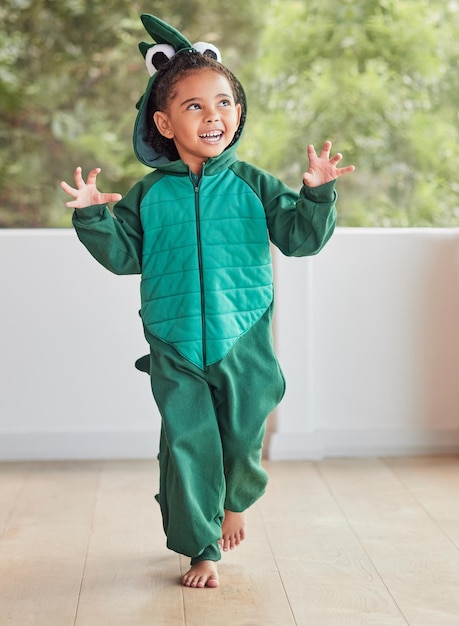 Child smile and excited in halloween dinosaur costume at home playing role and having fun at party Happy kid being playful with fantasy character in living room mimic animal actions ready to roar