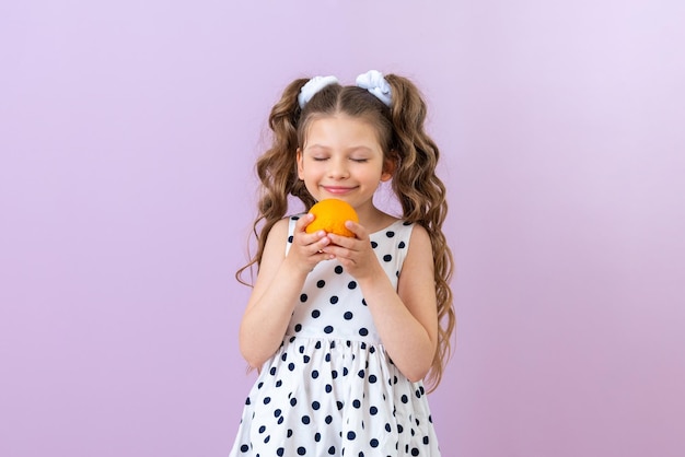 A child sniffs an orange on an isolated background Vitamin for baby food