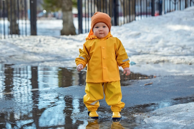 A child stands in the middle of a puddle in the park