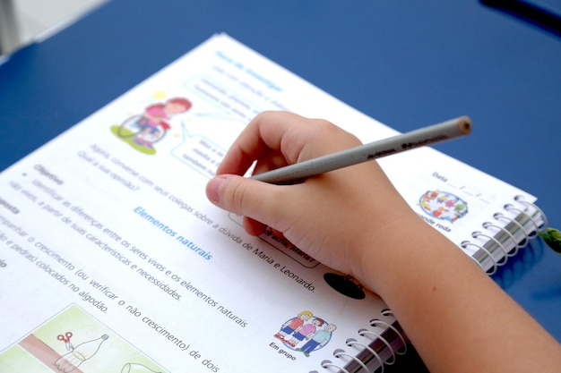 Child studying in a classroom with books and notebooks on the table