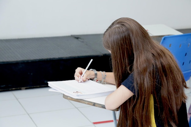 Child studying in a classroom with books and notebooks on the table