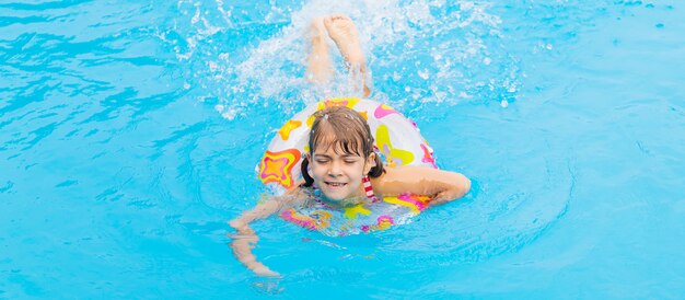 The child swims in the pool in the summer