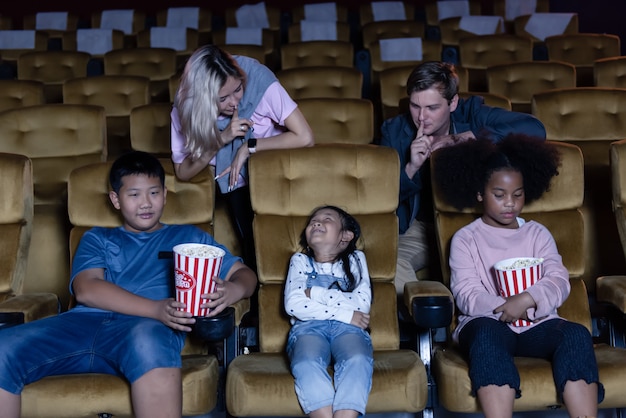 Child talking and playing while watching movie in the theatre.