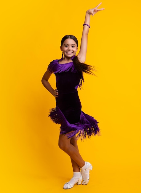 Child teen girl dancing rumba samba chachacha Ballroom dance school for teenager kids girl Dress movement Ballroom teenager dancer isolated on studio yellow background Latin classic dance