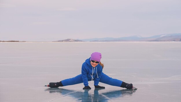 The child train on ice speed skating The athlete stretches warms up rest The kid girl skates in winter in sportswear sport glasses Children speed skating short long track Outdoor slow motion