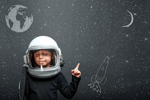 Photo child wants to fly an airplane wearing an airplane helmet