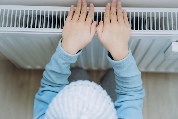 Child warming hands over heater Energy crisis in Europe