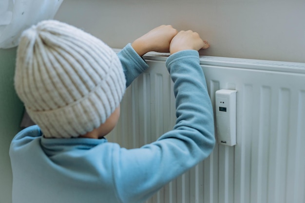 Child warming hands over heater Energy crisis in Europe