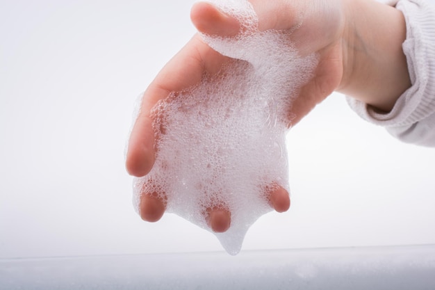 Child washing hands in foam