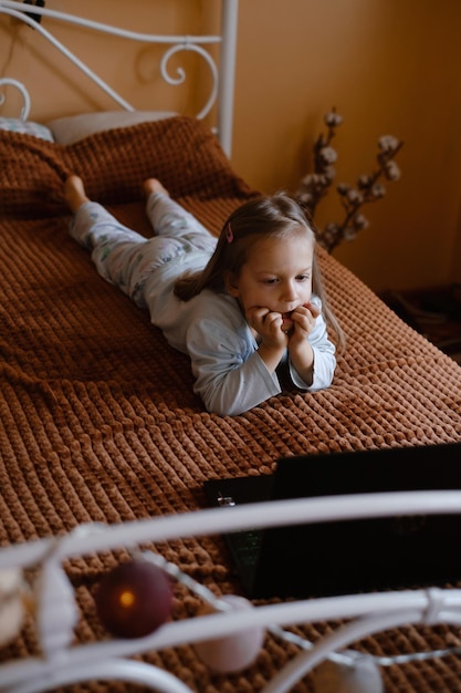 Child watching cartoons on the bed