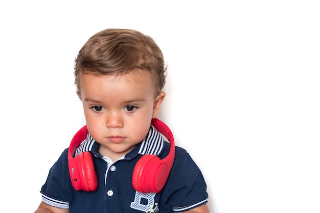 Child watching videos on mobile phone with red headphones and dark blue shirt