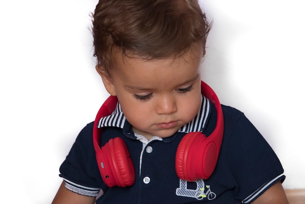 Child watching videos on mobile phone with red headphones and dark blue shirt