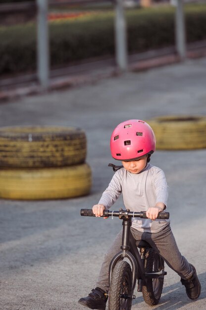 Photo a child wearing a helmet rides a bike