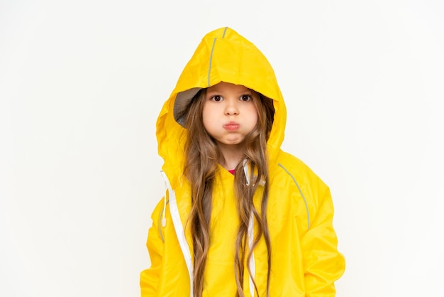 A child wearing a raincoat hood puffed out her cheeks on a white isolated background