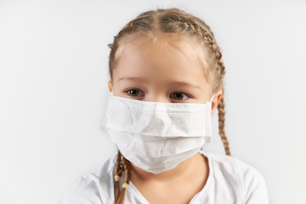 Child in a white medical mask on a white background