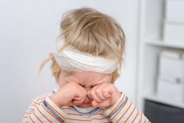 Child with bandaged head crying child abuse