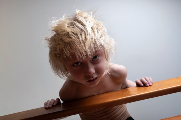 Child with blond hair leaned over the banister Safety of child in house