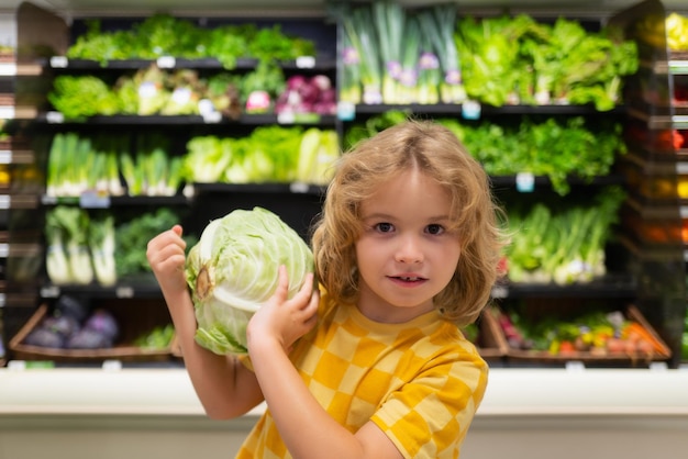 Child with cabbage shopping with kids kid buying fruit in supermarket little boy buy fresh vegetable