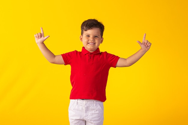 Child with facial expressions in a studio photo over colored background.