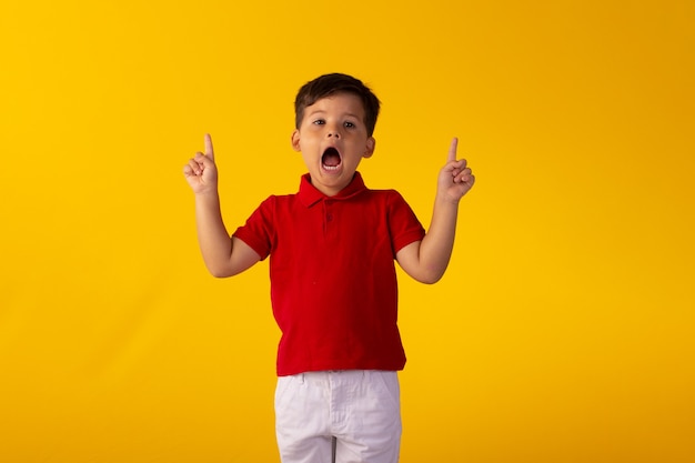 Child with facial expressions in a studio photo over colored background.