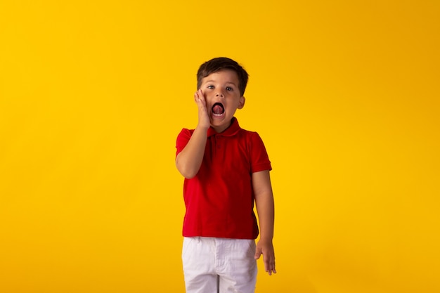 Child with facial expressions in a studio photo over colored background.