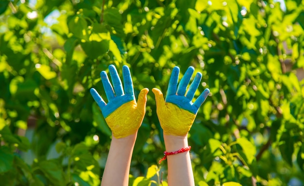 A child with the flag of Ukraine painted on his hands Selective focus