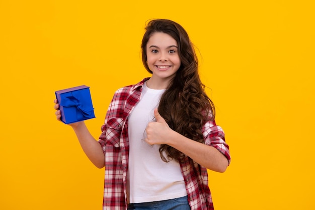 Child with gift present box on isolated background Presents for birthday Valentines day New Year or Christmas Happy teenager positive and smiling emotions of teen girl