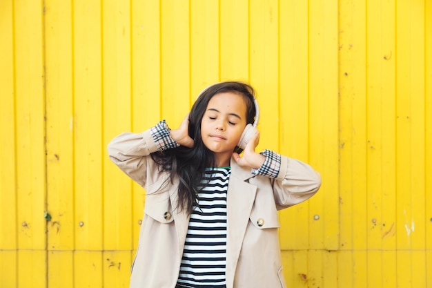 A child with headphones listening to music Audiobook concept Learning audio lessons a little girl wi