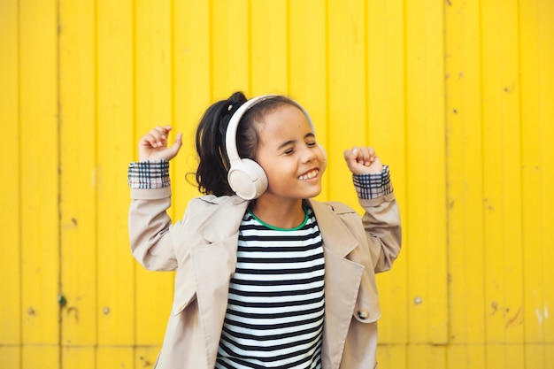 A child with headphones listening to music Audiobook concept Learning audio lessons a little girl wi