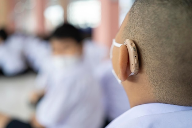 A child with a hearing aid The boy assumes hearing aid