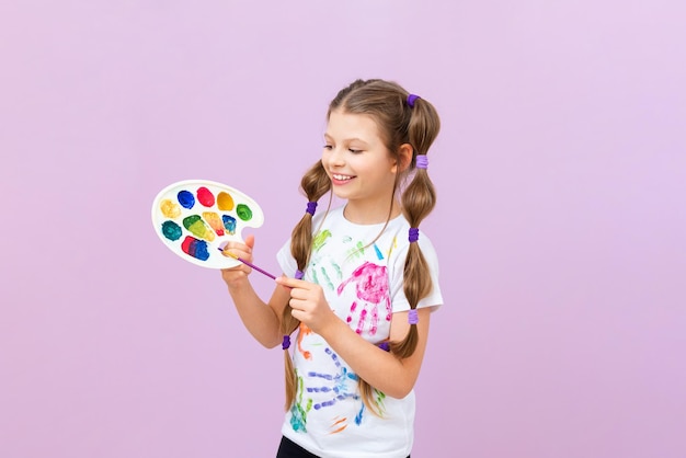 A child with paints on an isolated background a little girl is fond of painting