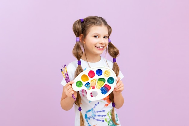 A child with paints on an isolated background a little girl is fond of painting