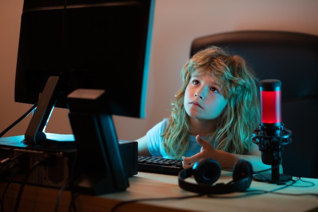 Child with pc computer at night A pretty child learns a lesson using a desktop computer at home Home education