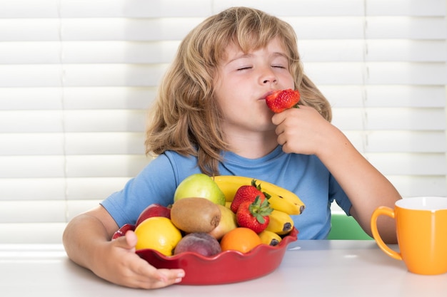 Child with strawberry summer fruits child eats organic food healthy vegetables with vitamins proper