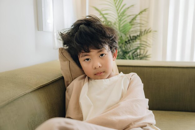 a child with a white robe on and a green plant in the background