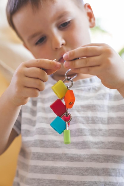 The child works with Montessori material with colored locks Picks up keys Develops fine motor skills Intellect game playing early development primary education letters learning