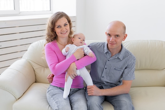 Childgood, parenthood, people concept - baby on the hands of parents on a white background.