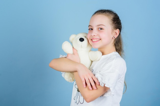 Childhood concept Lovely small girl smiling happy face with favorite toy Best friends Happy childhood Imaginary friend Little girl play with soft toy teddy bear Sweet childhood Child care